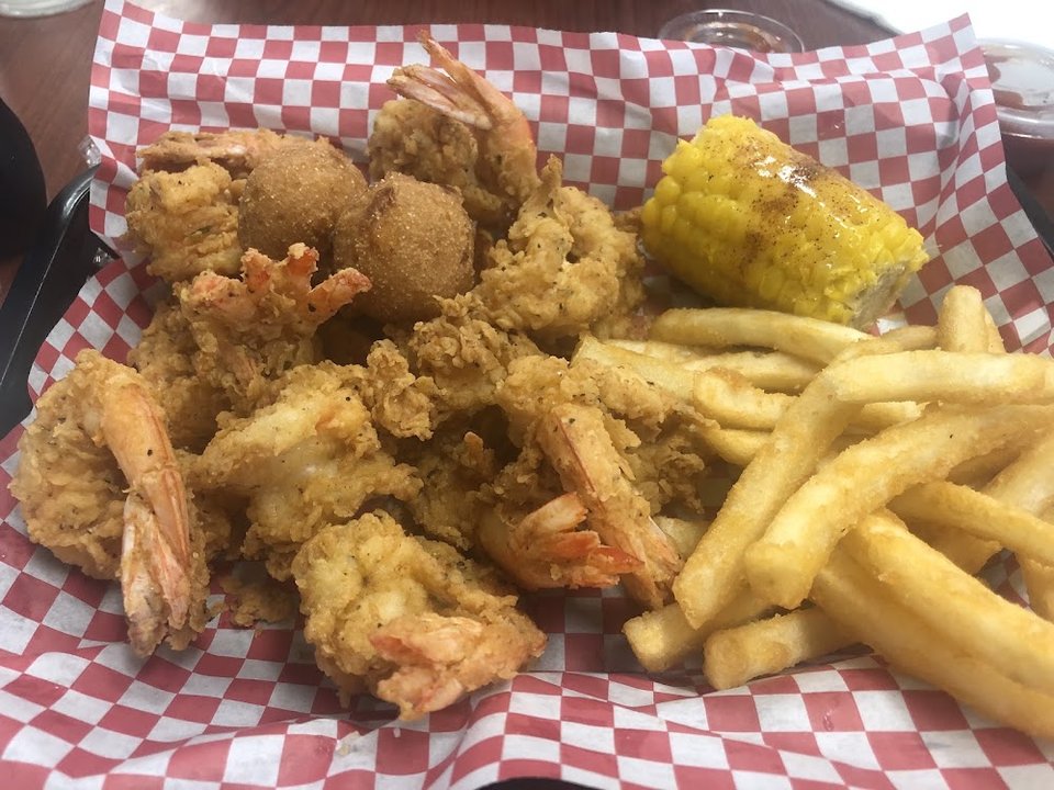 Menu board with fried seafood platters and burgers.
